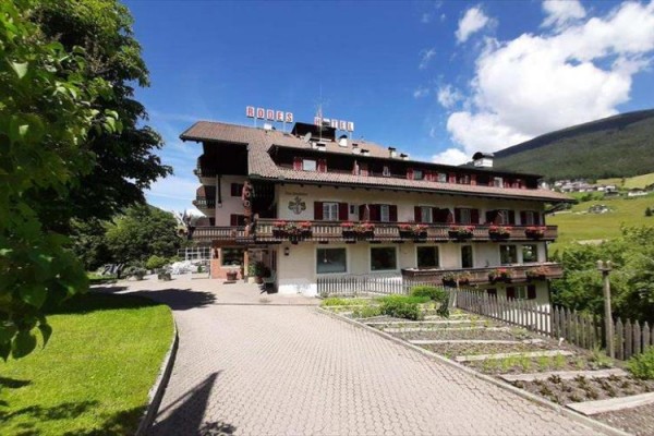 Hotel w alpejskim krajobrazie z niebieskim niebem.