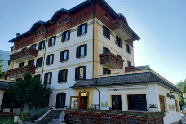 Budynek hotelu z drewnianymi balkonami i ozdobną fasadą.