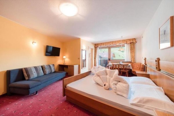 Pokój hotelowy z łóżkiem małżeńskim, kanapą i widokiem z okna.