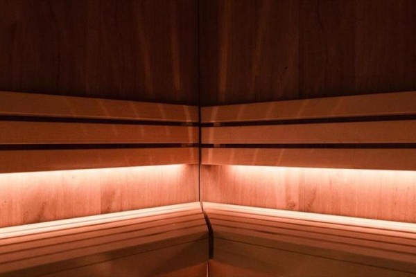 Drewniana sauna z przyciemnionym oświetleniem.