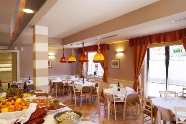Restauracja z nakrytymi stołami, klasycznym wystrojem i ofertą dań na stołach.