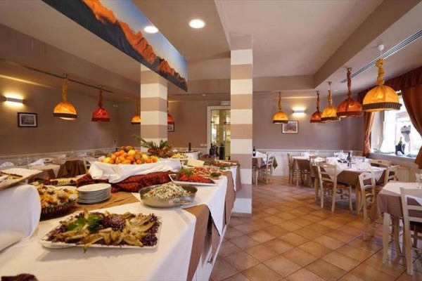 Restauracja z rzędem stołów i bufetem pełnym jedzenia.