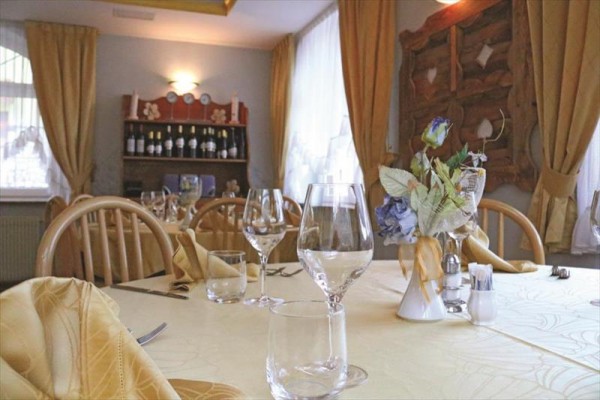Elegancki stół jadalny z kieliszkami i kwiatową dekoracją w przytulnej restauracji.