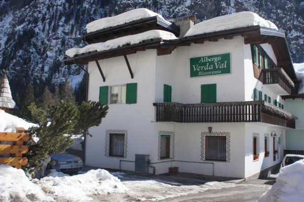 Górski hotel z napisem „Albergo Verda Val Ristorante” pokryty śniegiem.