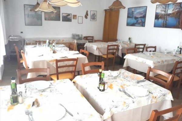 Restauracja ze stolikami przygotowanymi do serwowania.