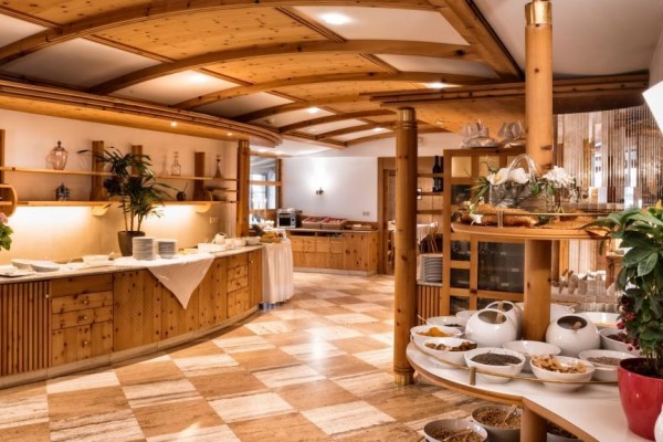 Elegancka hotelowa sala śniadaniowa z drewnianymi meblami i podłogą.