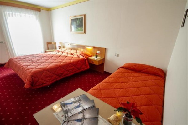 Pokój hotelowy z dwoma łóżkami i czerwonym dywanem.