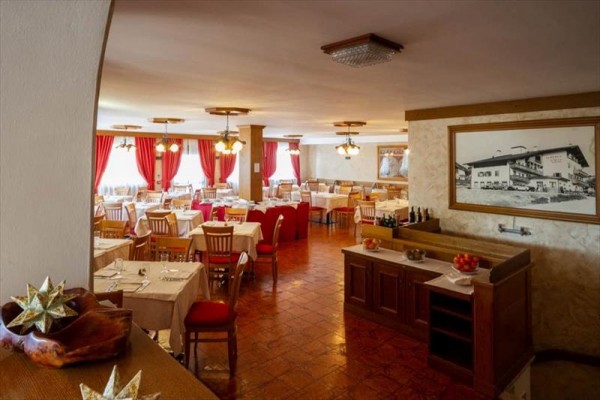 Restauracja z drewnianymi meblami i czerwonymi zasłonami.