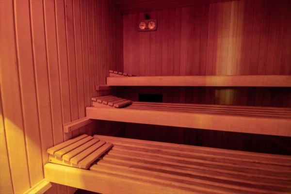 Drewniana sauna z trzema ławkami.