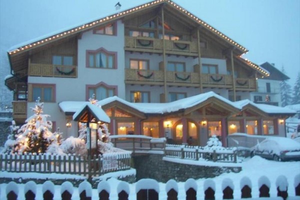 Górski hotel z oświetleniem i zaśnieżonym otoczeniem.