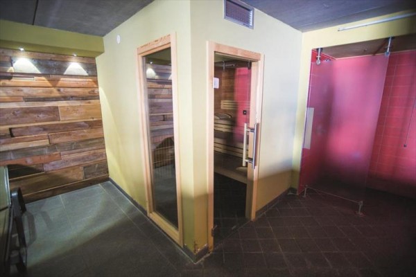 Sauna w pomieszczeniu z drewnianym wyłożeniem i kabiną prysznicową.