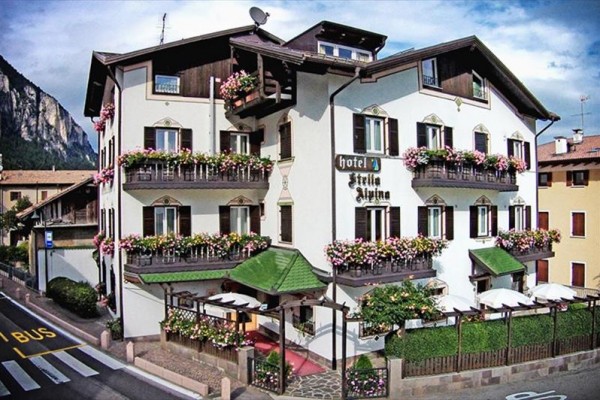 Tradycyjny hotel ozdobiony kwiatami z balkonem i tarasem przy górze.