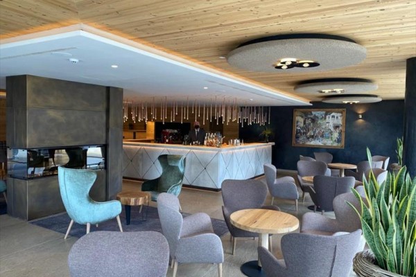 Nowoczesny hotelowy salon z komfortowym miejscem do siedzenia i barem.