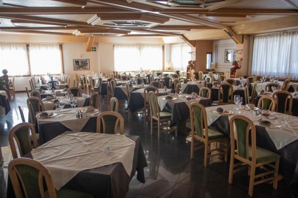 Restauracja z nakrytymi stołami i drewnianymi krzesłami.