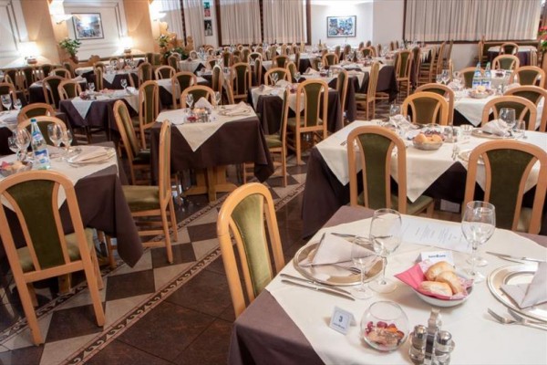 Restauracja z wieloma stołami nakrytymi do kolacji.