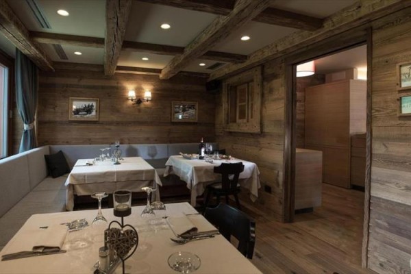 Restauracja z drewnianymi ścianami i nakrytymi stołami.
