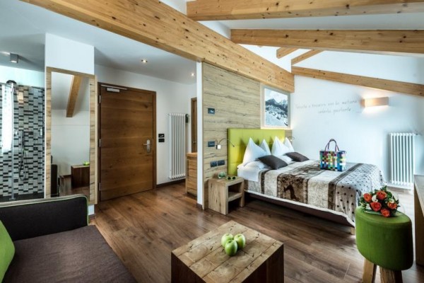 Nowoczesny pokój hotelowy z drewnianymi elementami i otwartą łazienką.