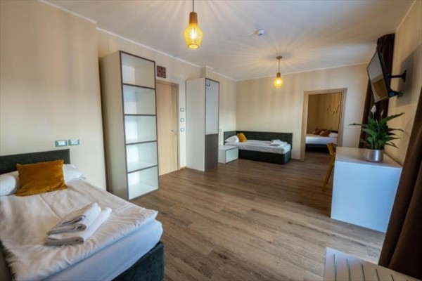 Nowoczesny, przestronny pokój hotelowy z dwoma łóżkami, szafą i biurkiem.