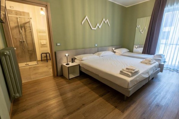Nowoczesny pokój hotelowy z dwoma łóżkami i łazienką.