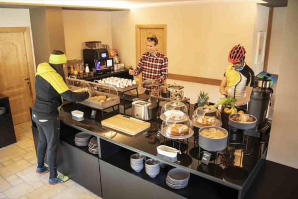 Ludzie wybierają jedzenie z bufetu śniadaniowego w hotelu.