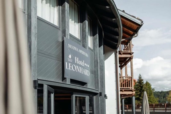 Fasada górskiego hotelu z drewnianymi elementami i napisem 