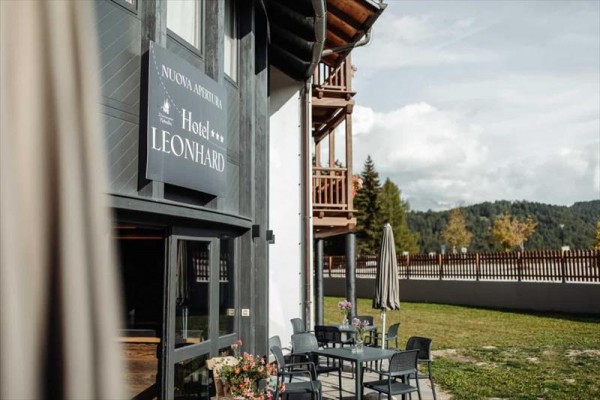 Zewnętrzne miejsce do siedzenia przy hotelu o nazwie Leonhard w górskim otoczeniu.