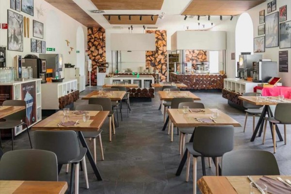 Nowoczesna restauracja z drewnianym wystrojem i nakrytymi stołami.