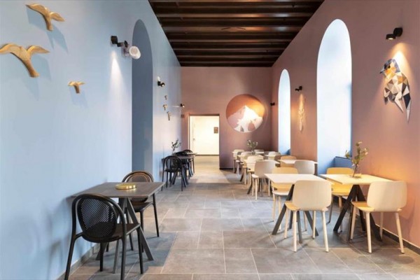 Nowoczesne wnętrze kawiarni z kolorowymi ścianami i minimalistycznymi meblami.