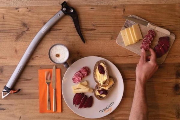 Śniadanie z chlebem, serem, mięsem, kawą i czekanem na drewnianym stole.