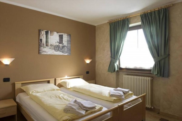 Jasny salon z sofą, stołem jadalnym i obrazami na ścianach.