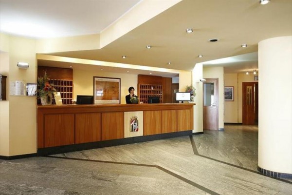 Recepcja w hotelowym holu z drewnianym blatem.