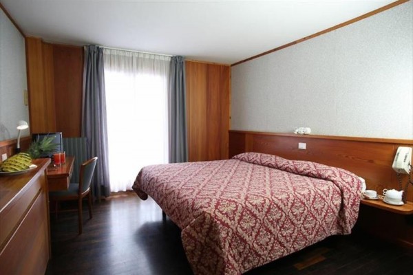 Pokój hotelowy z łóżkiem małżeńskim i biurkiem.