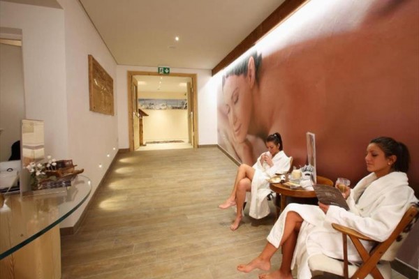 Dwie kobiety w szlafrokach odpoczywają w poczekalni spa.