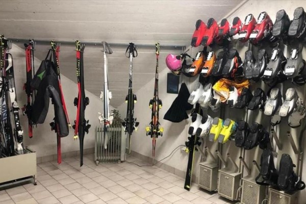 Narty i buty narciarskie starannie ułożone w pomieszczeniu.