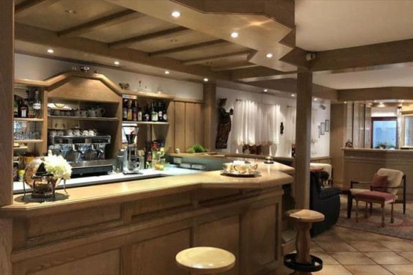 Elegancki drewniany bar z dobrze zaopatrzonymi półkami w przytulnym wnętrzu.
