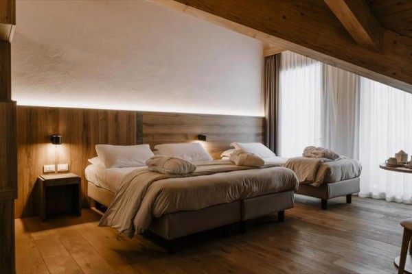 Nowoczesny pokój hotelowy z dwoma łóżkami i drewnianym wnętrzem.