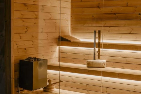 Drewniana sauna z ławką i oświetleniem.