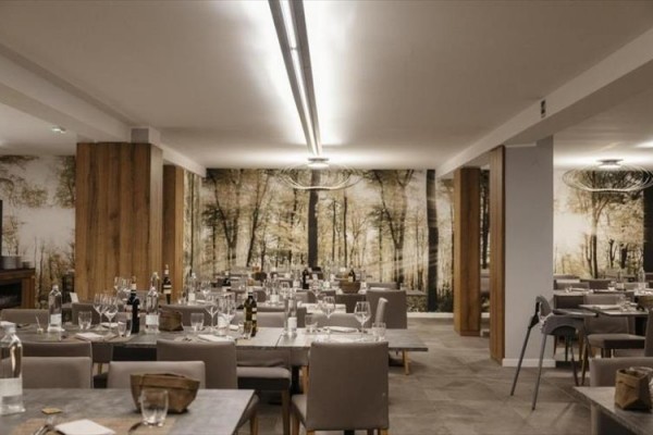 Nowoczesna restauracja z drewnianym wystrojem i stołami przygotowanymi dla gości.