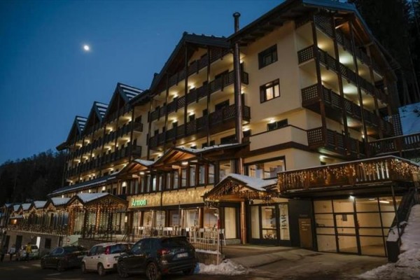 Duży budynek hotelu ozdobiony światłami o zmierzchu.